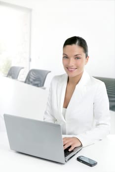 Modern businesswoman working in white office with laptop computer