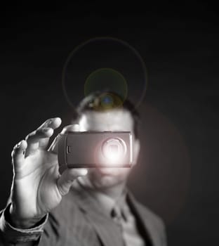 Businessman taking photos, mobile camera, black background