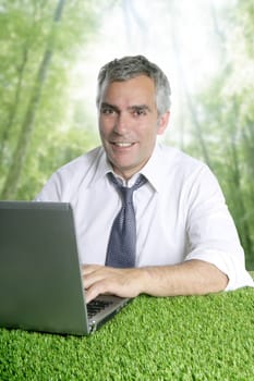 senior businessman working green grass desk computer forest jungle