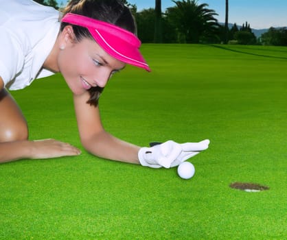 Golf green hole course woman humor flicking hand a ball inside in short putt