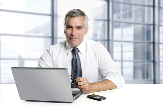 businessman senior gray hair working laptop interior modern white office