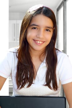 Latin teenager student smiling holding laptop indoor white house