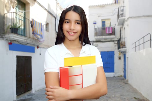 Brunette student young teen latin girl holding books white mediterranean village