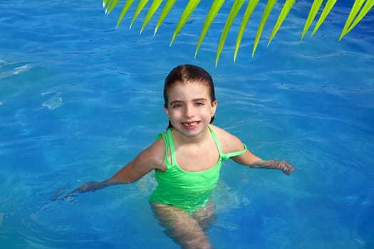brunette little girl in swimming pool smiling with missing front teeth