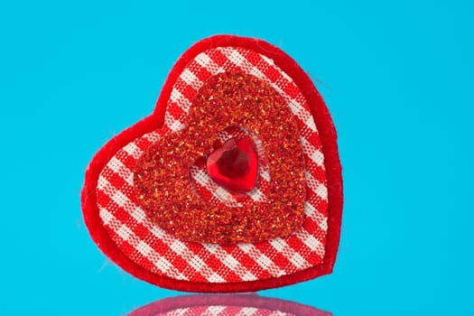 red decorative heart with reflection on blue background