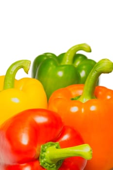 Orange, red, yellow and green peppers on a white background.