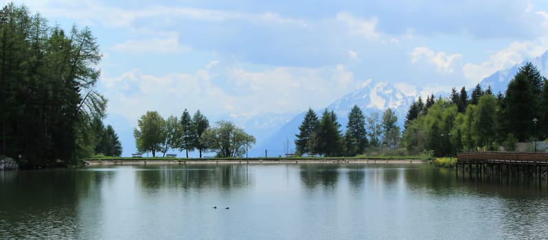Long lake, trees and mountain by summer, Cran Montana, Switzerland