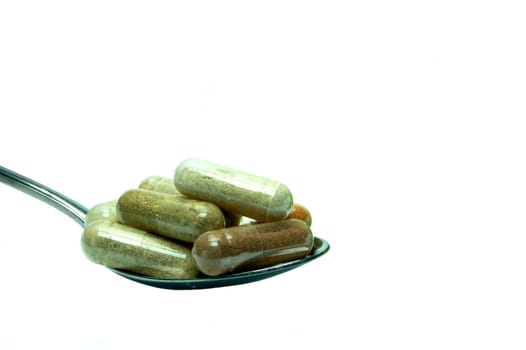 Herbal capsules on a spoon