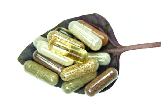 Herbal capsules on basil leaves