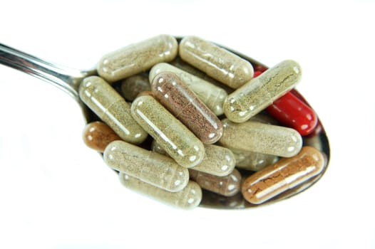 Herbal capsules on a spoon
