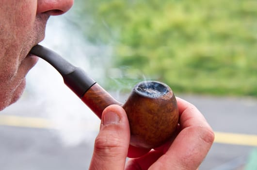 a man smokes his pipe