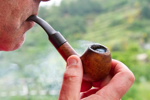 a man smokes his pipe