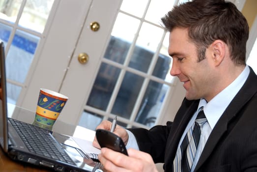 man in a suit taking notes with his laptop