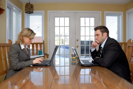 cute man and woman each on their laptops
