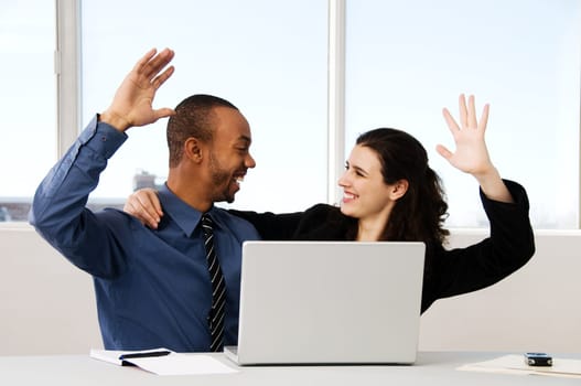 two business associates with a grey laptop