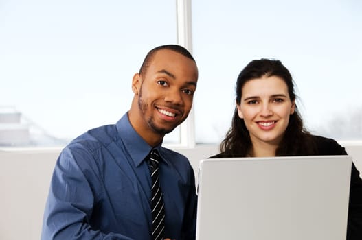 two business associates with a grey laptop