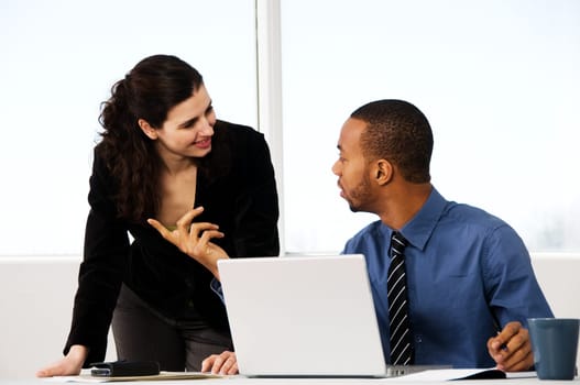 two business associates with a grey laptop