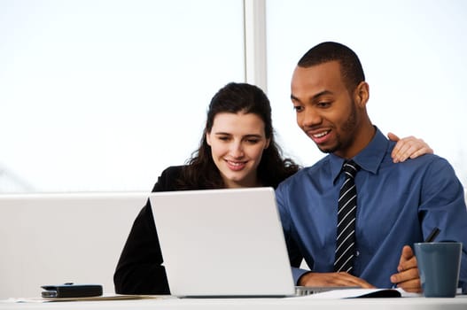 two business associates with a grey laptop