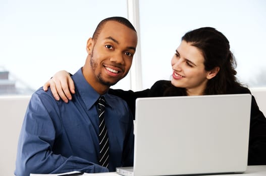 two business associates with a grey laptop