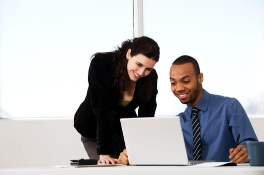 two business associates with a grey laptop