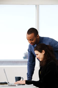 two business associates with a grey laptop