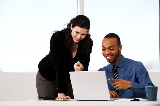 two business associates with a grey laptop