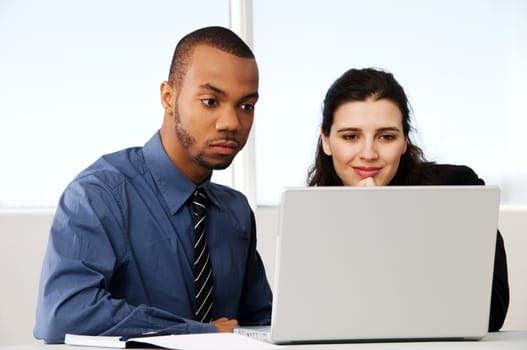 two business associates with a grey laptop