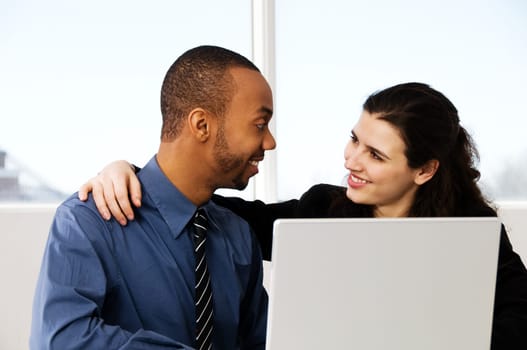 two business associates with a grey laptop