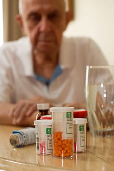 elderly man with all his pills and drugs