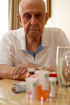 elderly man with all his pills and drugs