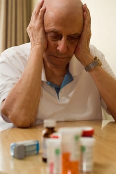 elderly man with all his pills and drugs