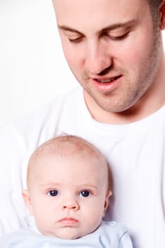 father holing his baby boy with blue eyes