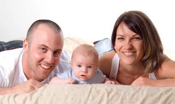 mom dad and the new born baby lying on the bed