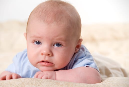 new born baby in blue posing on bed