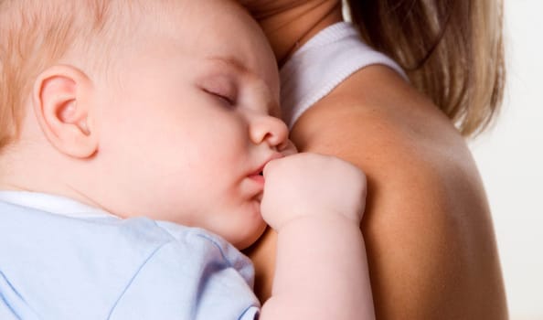 New born baby boy sleeping on his mother