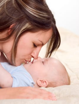 mom kissing her lovely baby boy portrrait