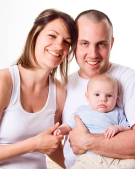 mom dad and the new born baby sitting on the bed