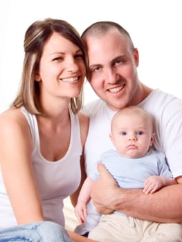 mom dad and the new born baby sitting on the bed