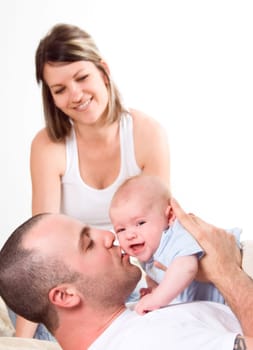 mom dad and the new born baby sitting on the bed