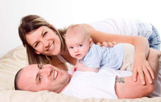 mom dad and the new born baby lying on the bed