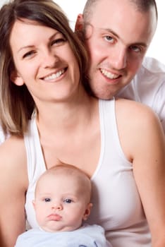 mom dad and the new born baby sitting on the bed