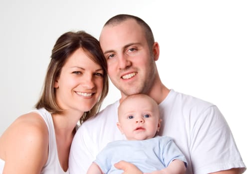 mom dad and the new born baby sitting on white