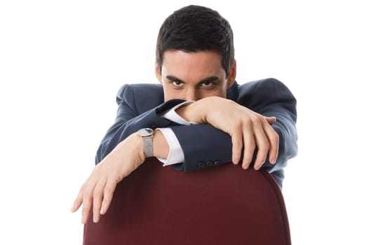 man in a blue suit hiding behind a chair