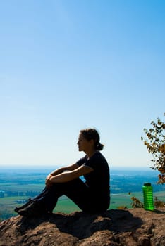sitting woman on top of a mountain