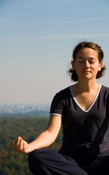 Woman on the top of a mountain meditating