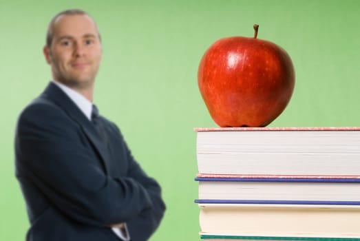 apple sitting on top of books in a classroom