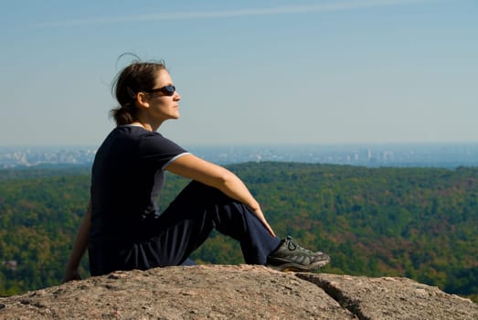 sitting woman on top of a mountain