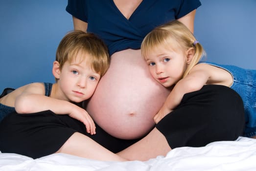 two cute kids with their pregnant mother