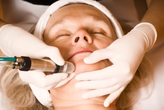 older woman getting electrolysis on he face