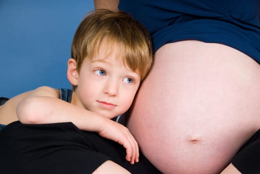 cute blond boy listening to the unborn child